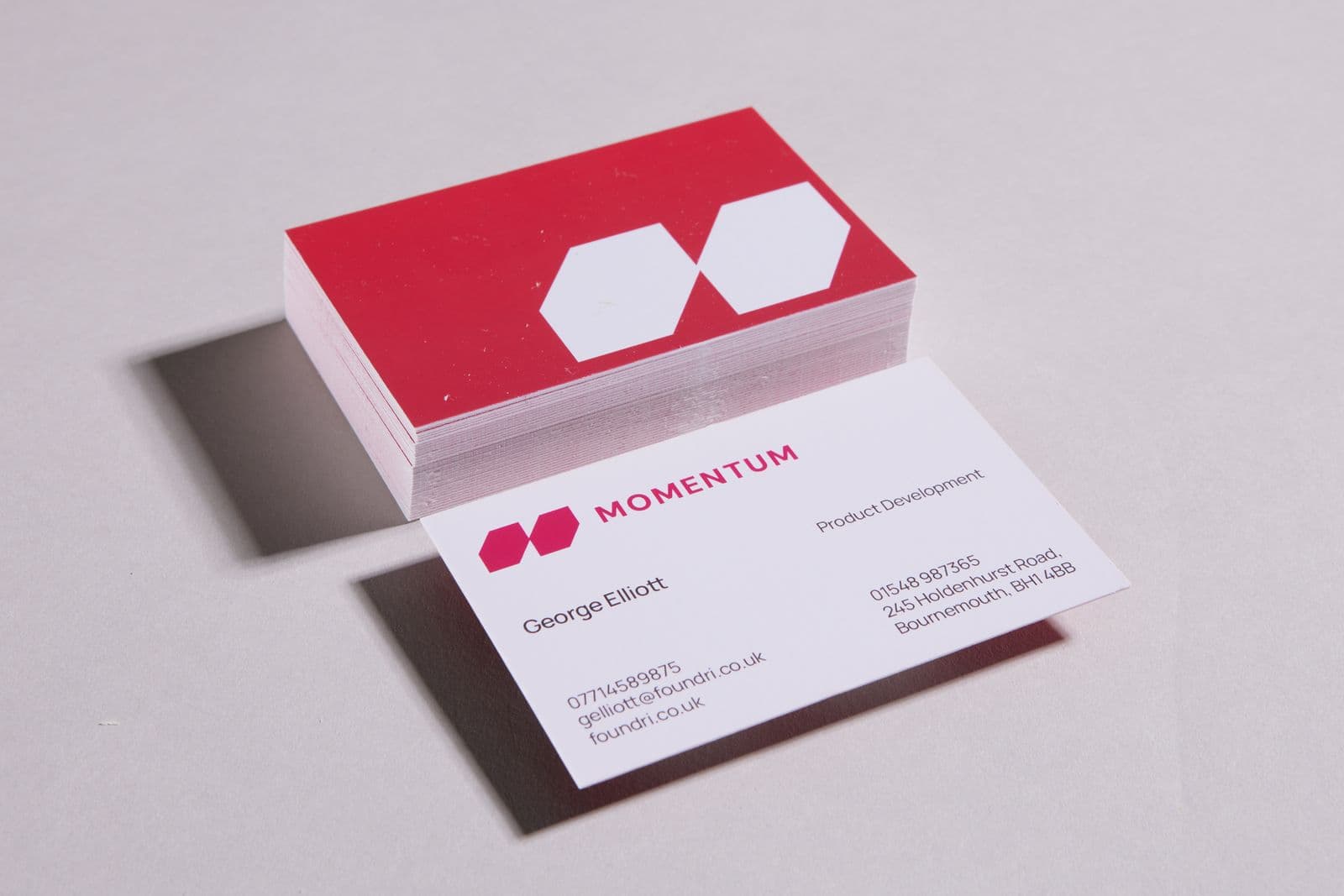 Stacks of red and white business cards with a printed name card in front