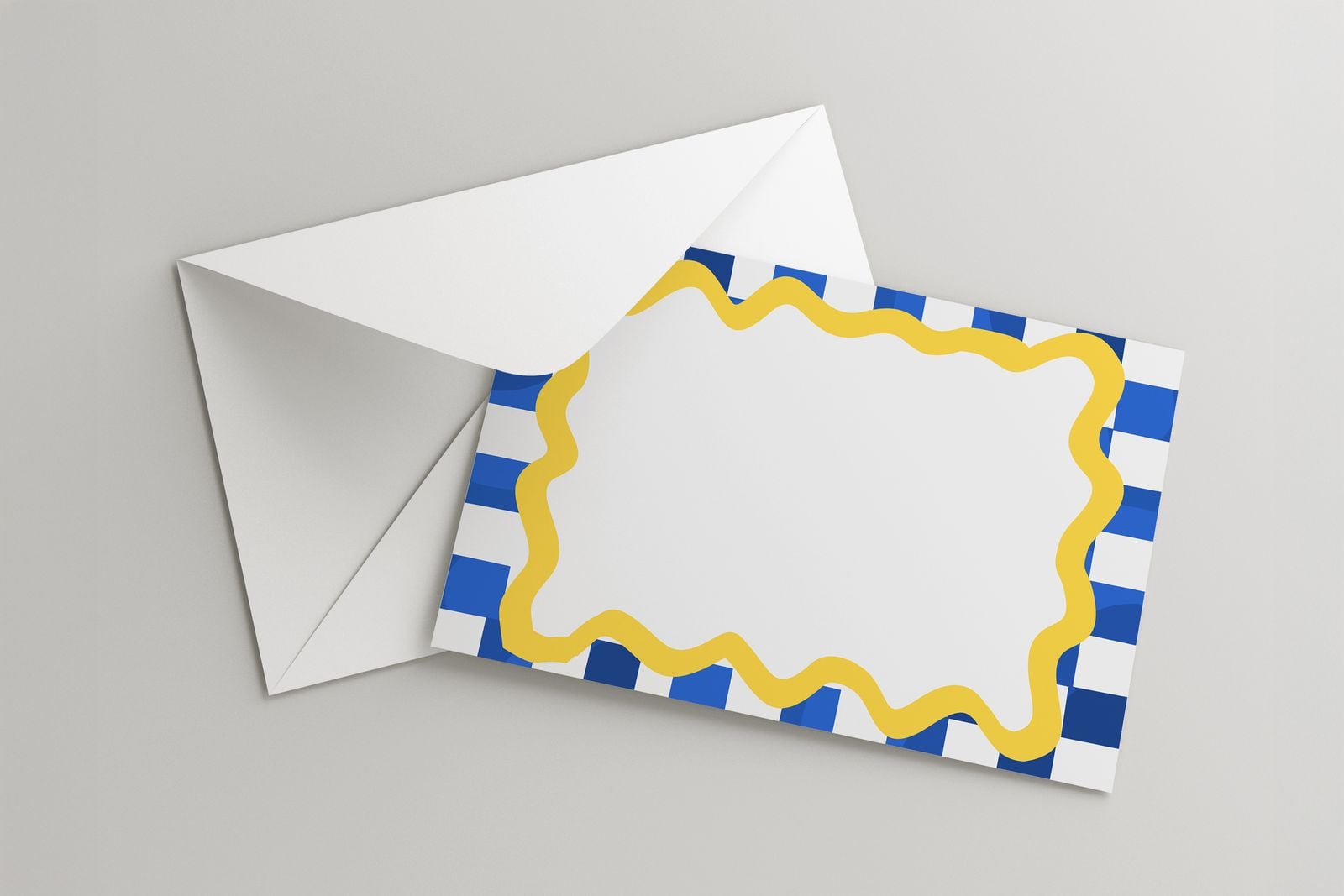 Note card with a blue check and yellow wavy border on a white envelope