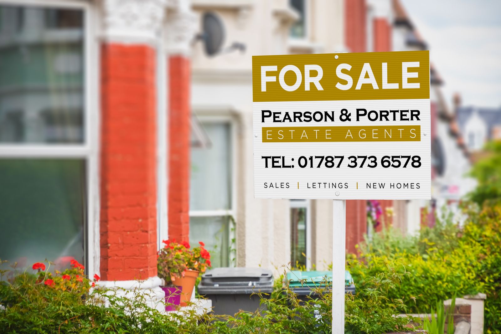 Estate agent’s “For sale” correx board outside a terraced house