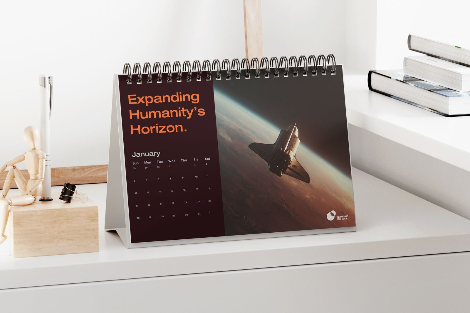 Desk calendar with a space shuttle photo on a white shelf