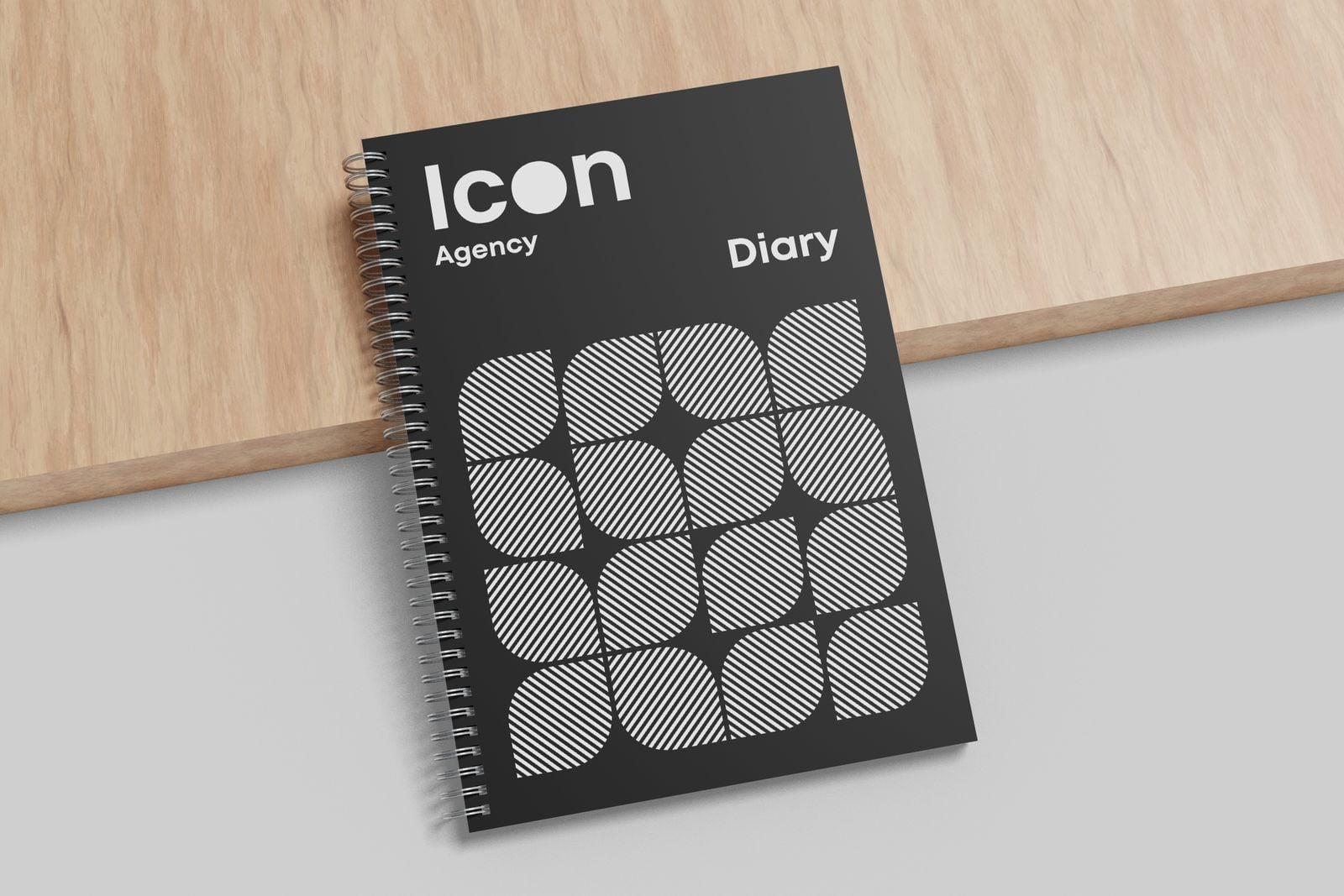 Black wiro diary with a geometric cover leaning on a wooden board