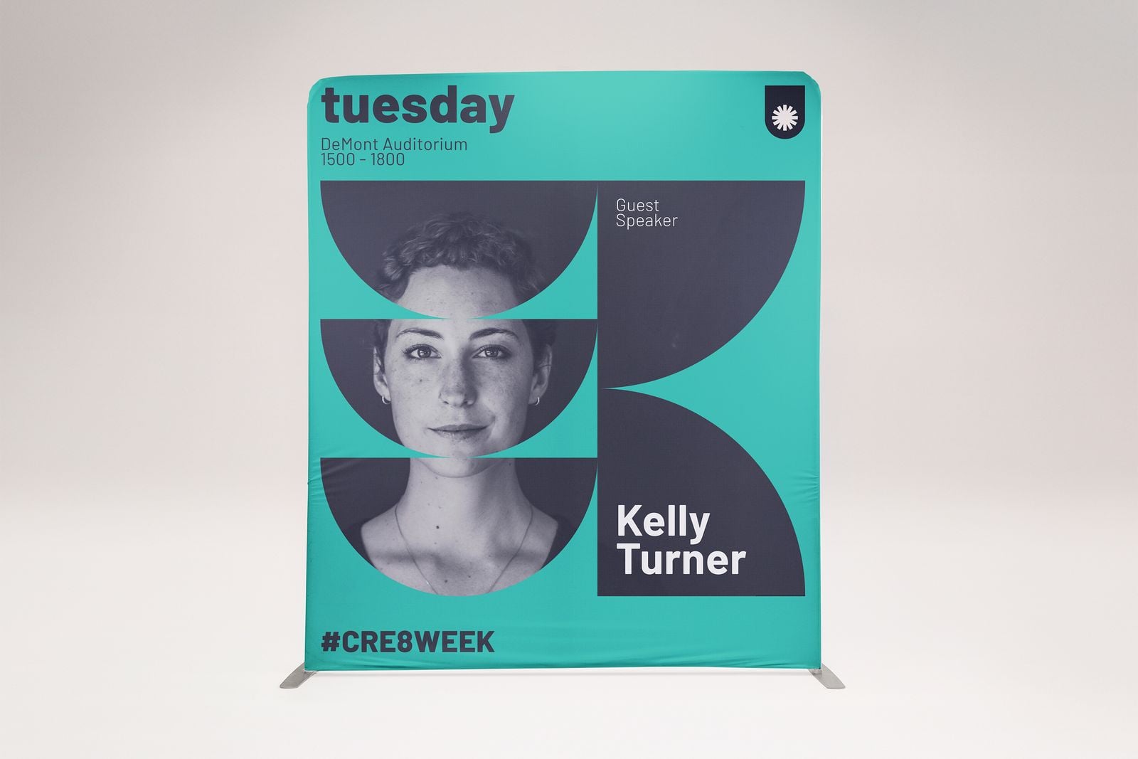 Teal fabric display wall announcing a guest speaker