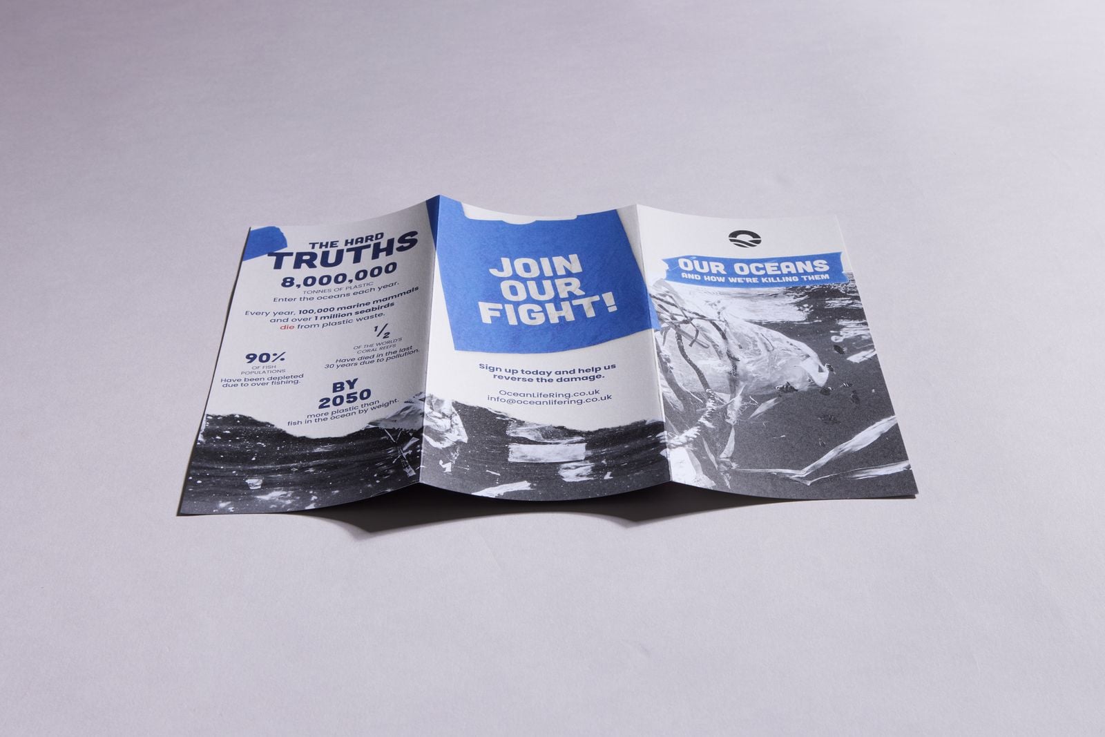 Roll-folded DL leaflet for an ocean charity lying open on a grey surface