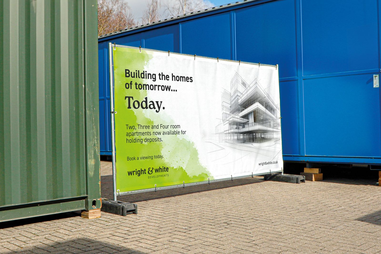 Printed cover for a housing developer on a Heras fence panel beside site cabins