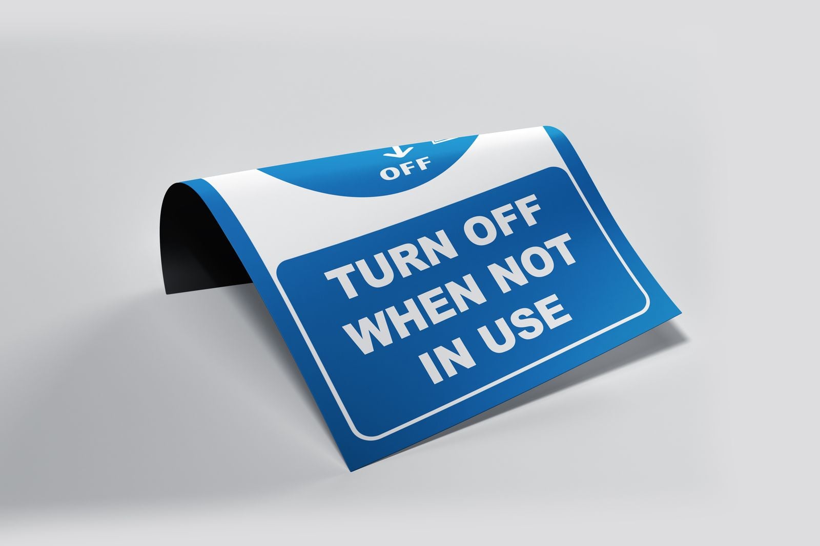 Flexible magnetic “Turn off when not in use” sign curling up at one edge