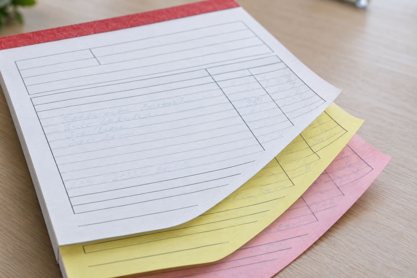 Triplicate NCR pad with white, yellow and pink copies fanned out