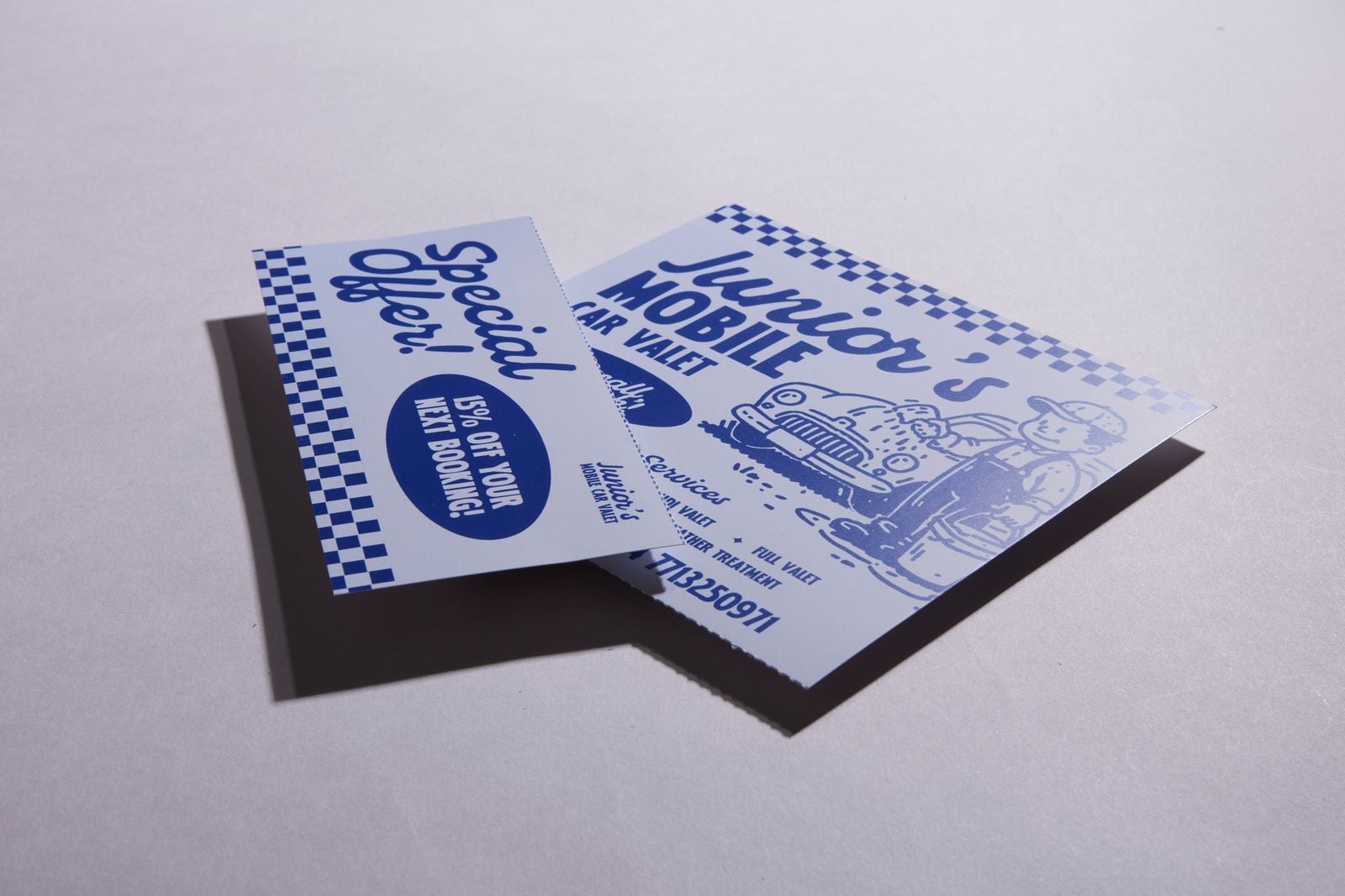 Blue and white car valet flyer with its perforated “Special offer!” voucher torn off and lying beside it