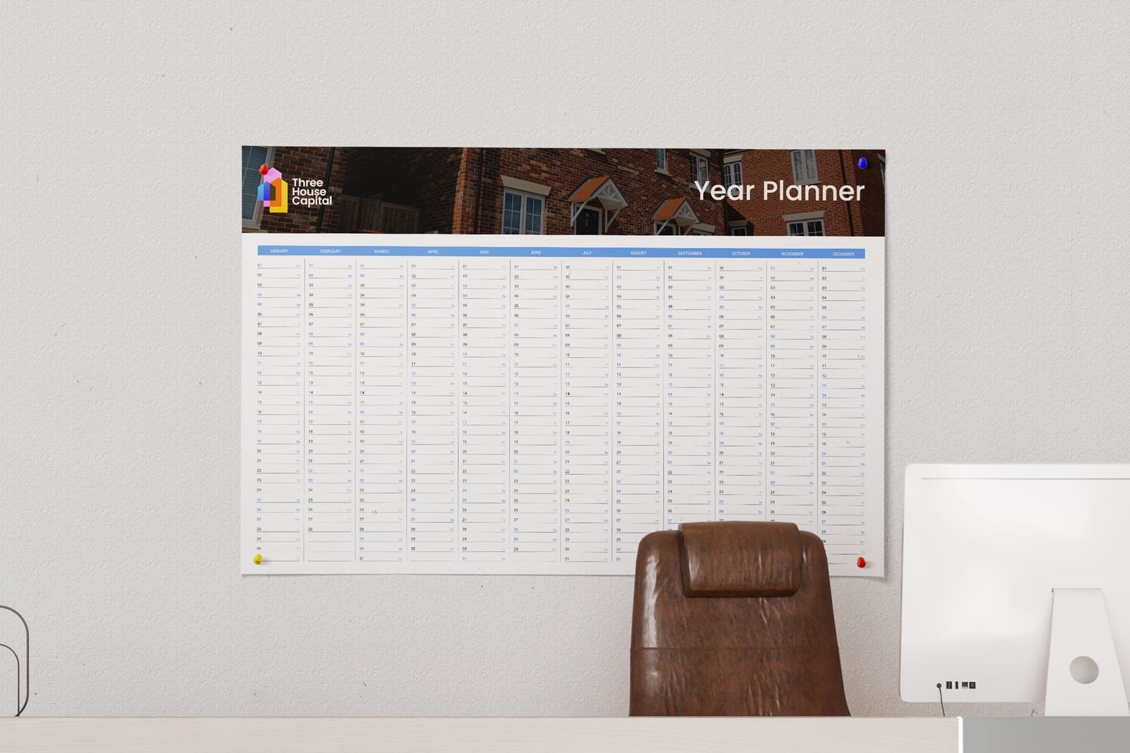 Year planner pinned to an office wall above a desk