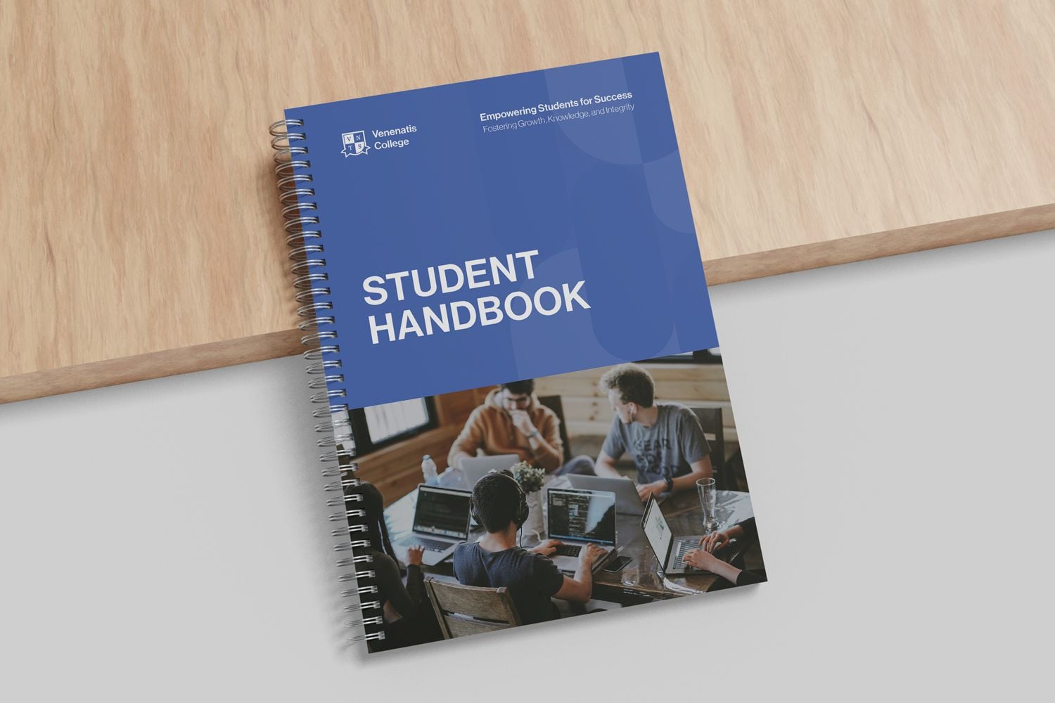 Wiro bound student handbook leaning against a wooden board
